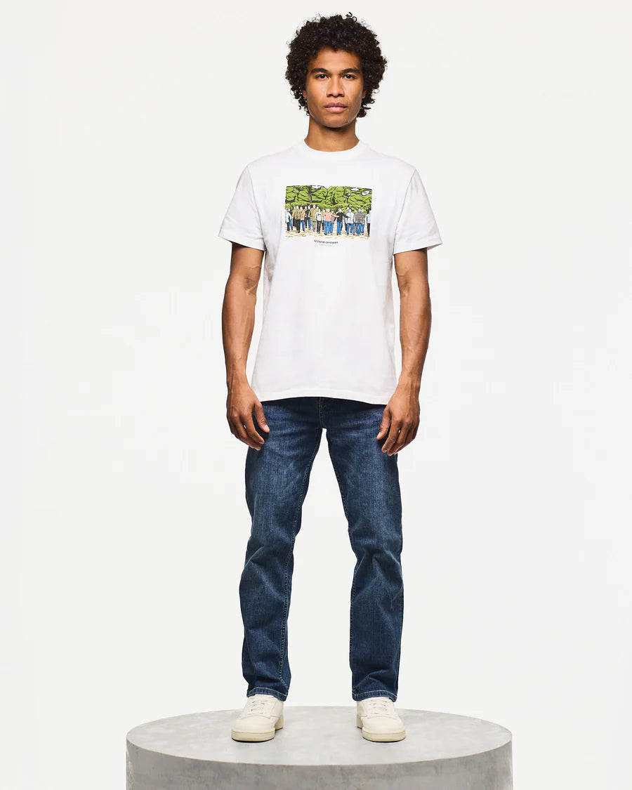 Man wearing a white t-shirt with a graphic design and blue jeans on a white background