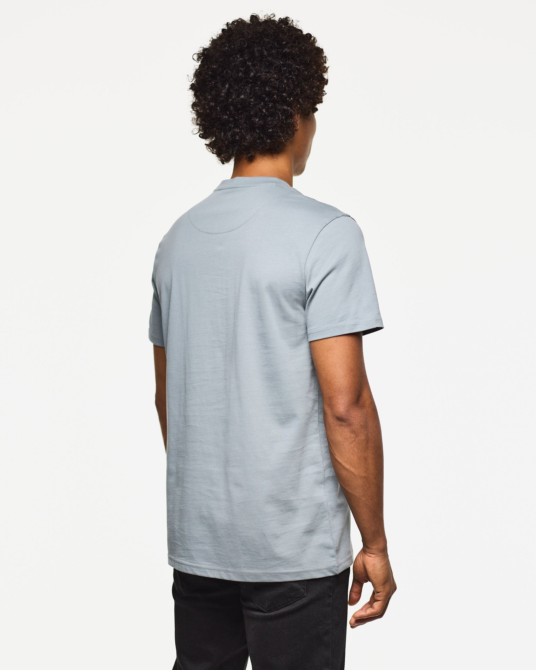 Person wearing a light blue polo shirt on a white background