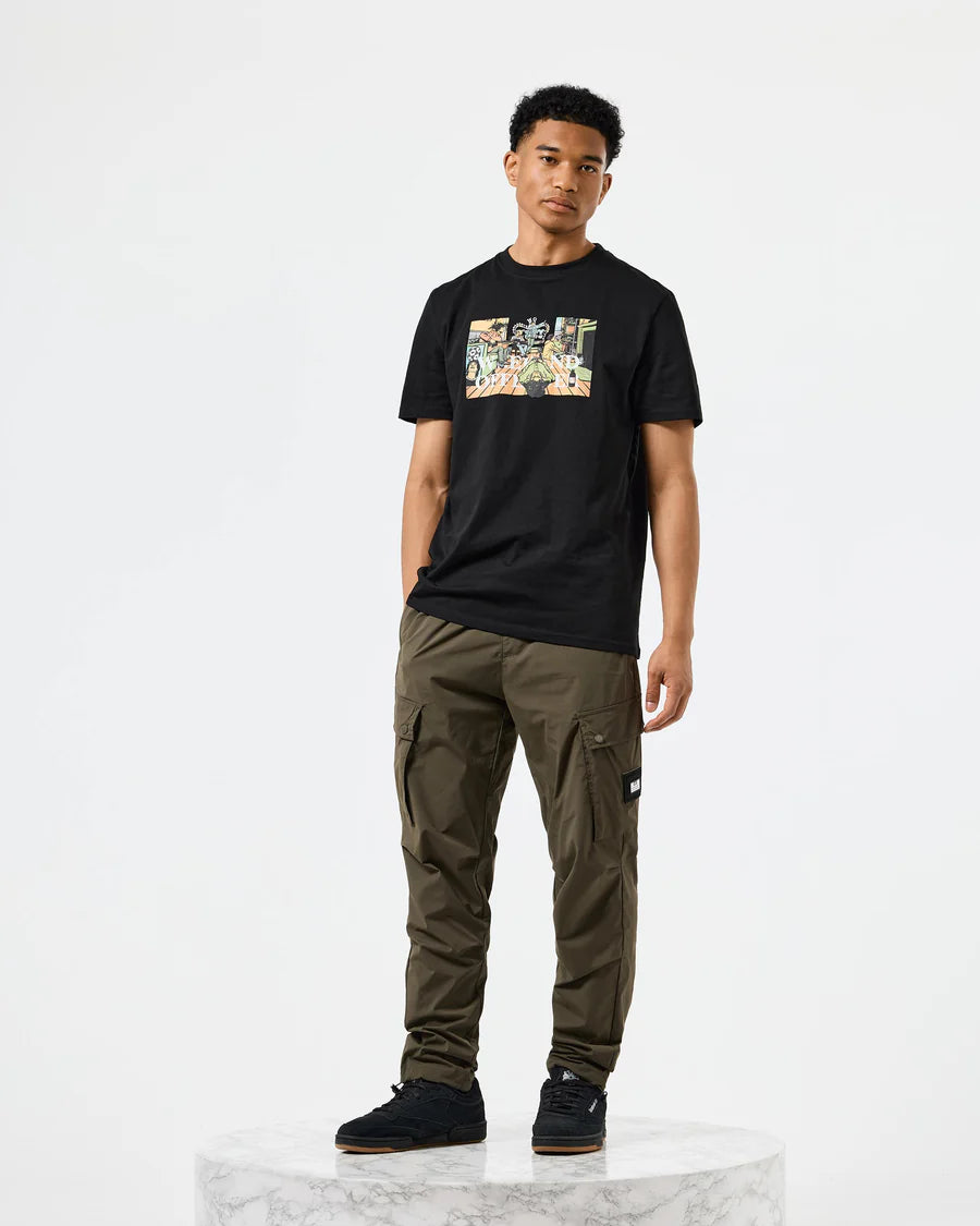 Person wearing a black t-shirt with a graphic design and green cargo pants on a white background