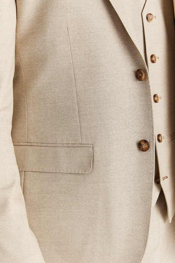 Close-up of a beige suit jacket with brown buttons on a light background