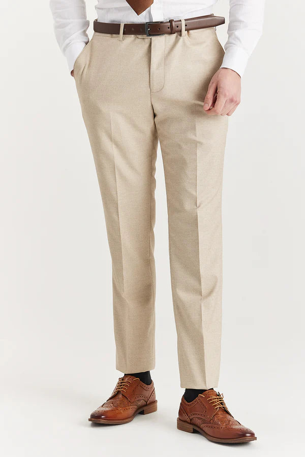 Person wearing beige dress pants with a brown belt and shoes on a white background