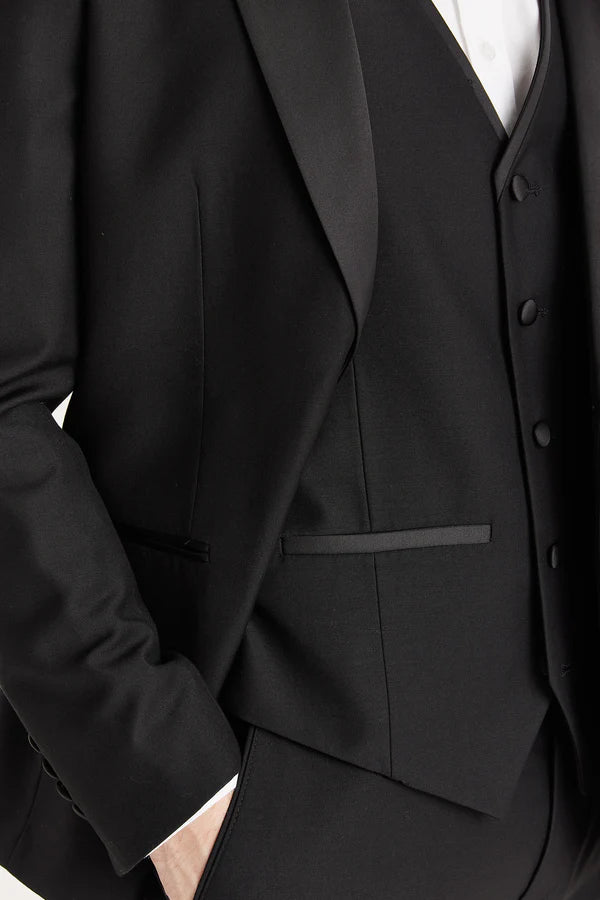 Close-up of a black suit jacket and vest on a white background
