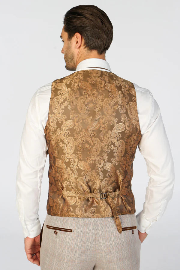 Man wearing a patterned vest over a white shirt on a plain background