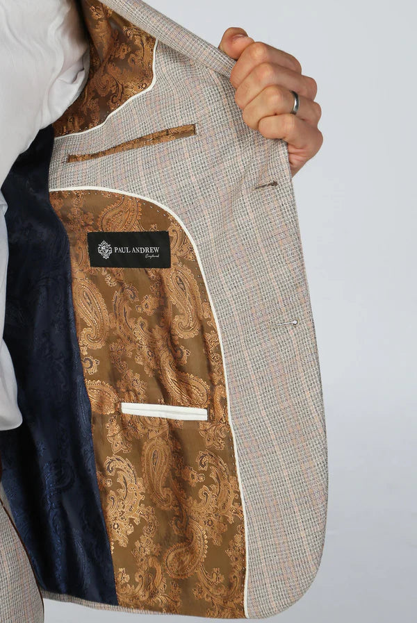 Close-up of a suit jacket with a brand label on a plain background