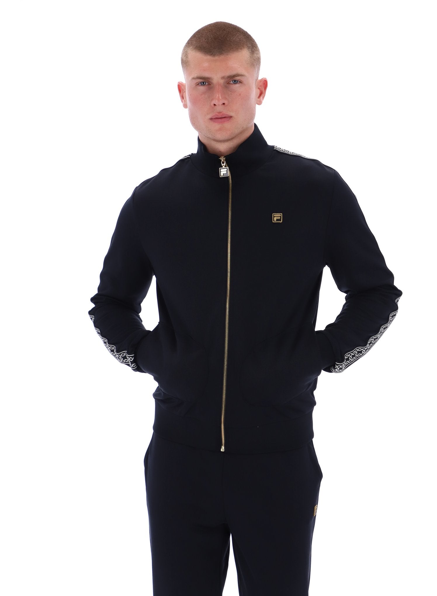 Man wearing a black tracksuit with gold zipper on a white background
