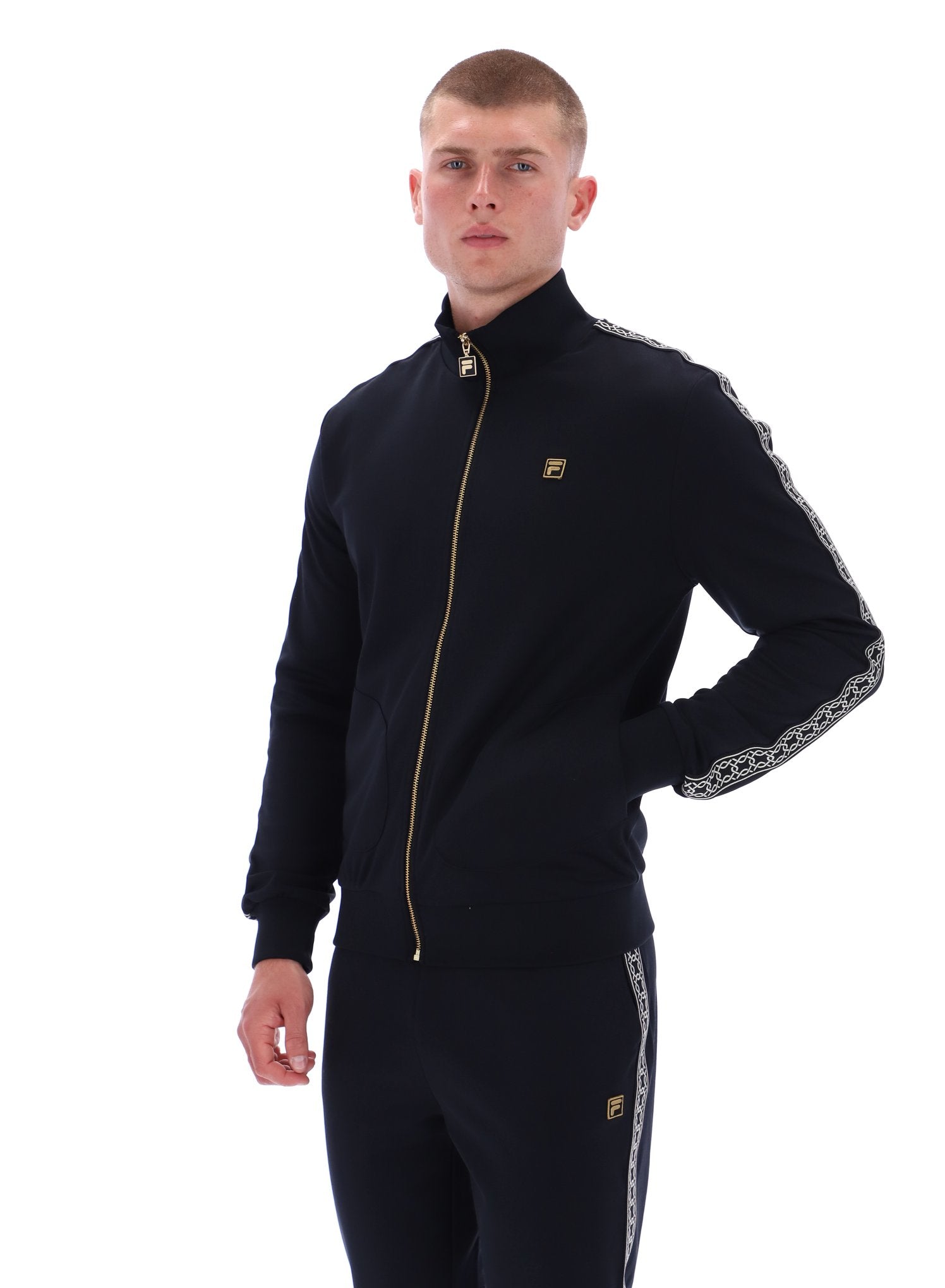 Man wearing a black tracksuit with gold accents on a white background