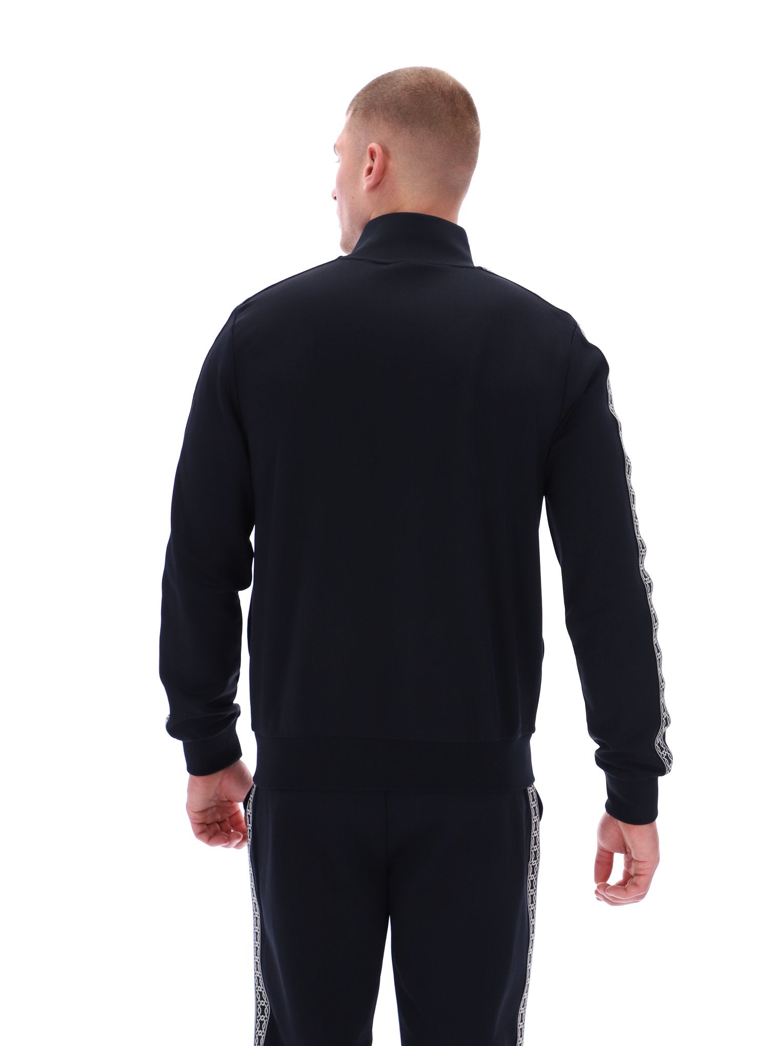 Man wearing a black tracksuit with white stripes on a white background