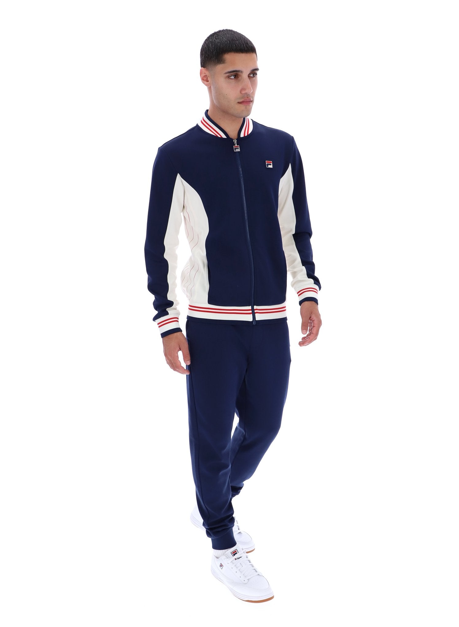 Man wearing a navy and white tracksuit with a brand logo on a white background