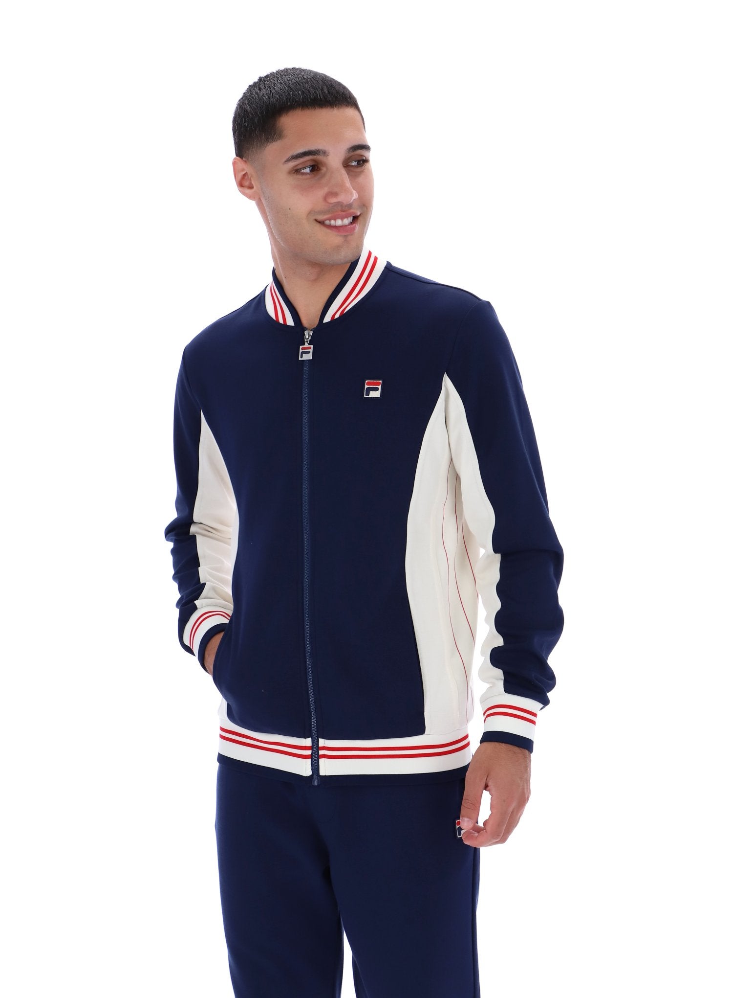 Man wearing a navy and white tracksuit with a visible brand logo on a white background