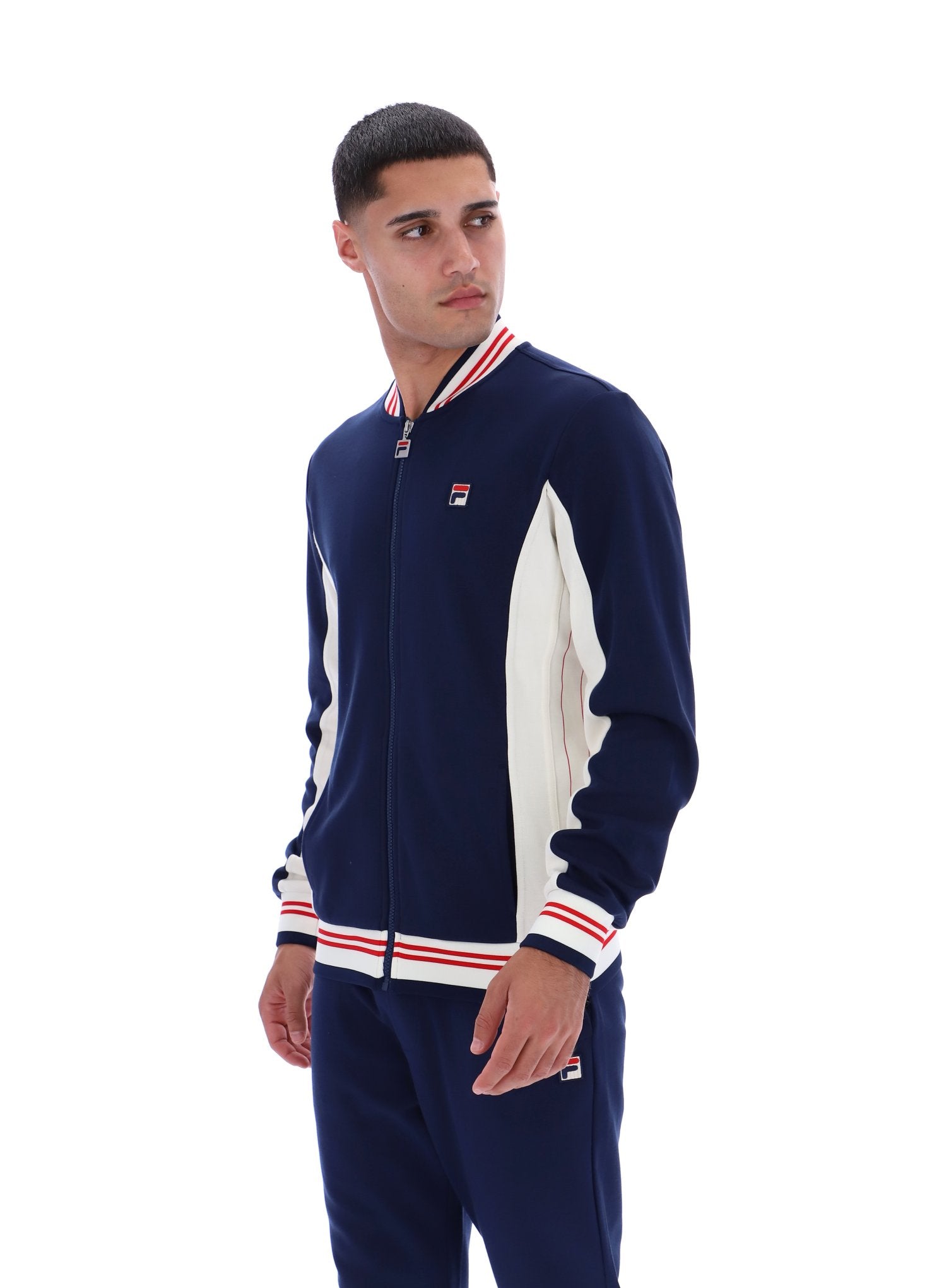 Man wearing a navy tracksuit with white and red accents on a white background