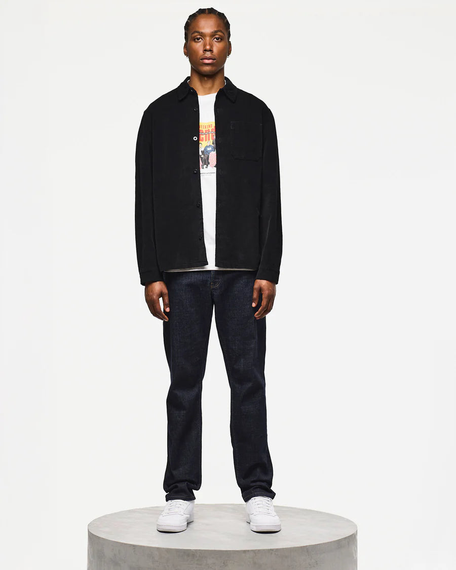 Person wearing a black jacket, white shirt, and dark jeans on a white background