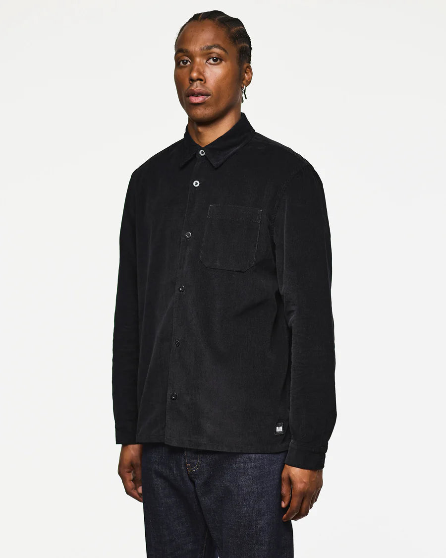 Person wearing a black shirt with a pocket on a white background