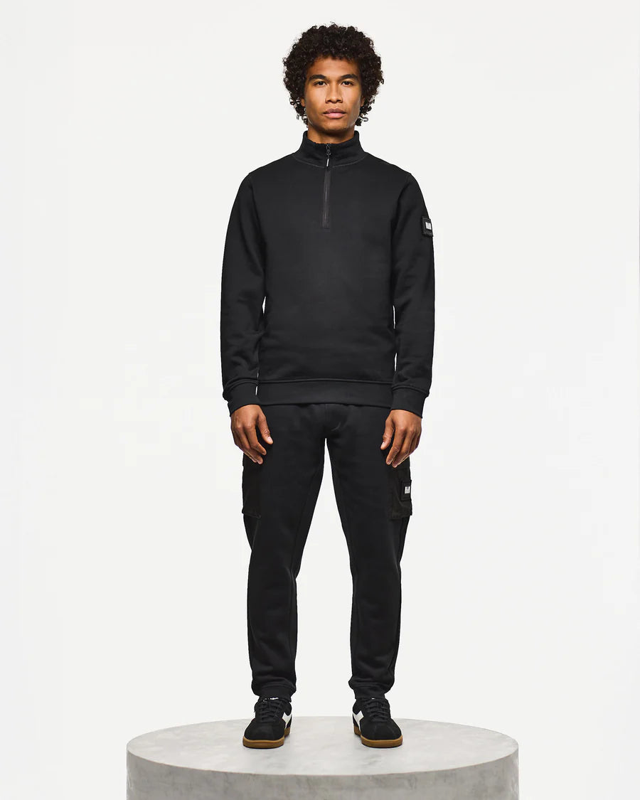 Person wearing a black tracksuit on a white background