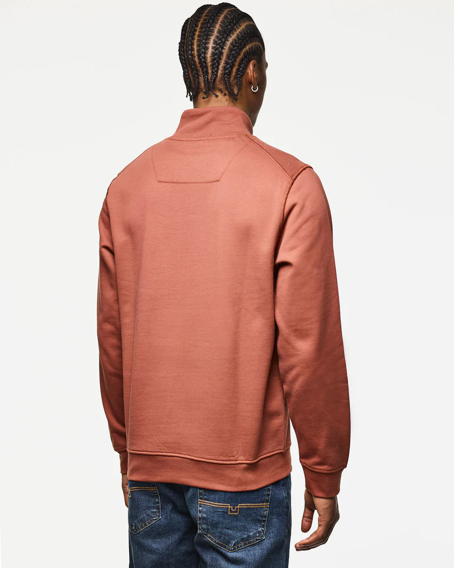 Person wearing a pink half-zip sweatshirt on a white background