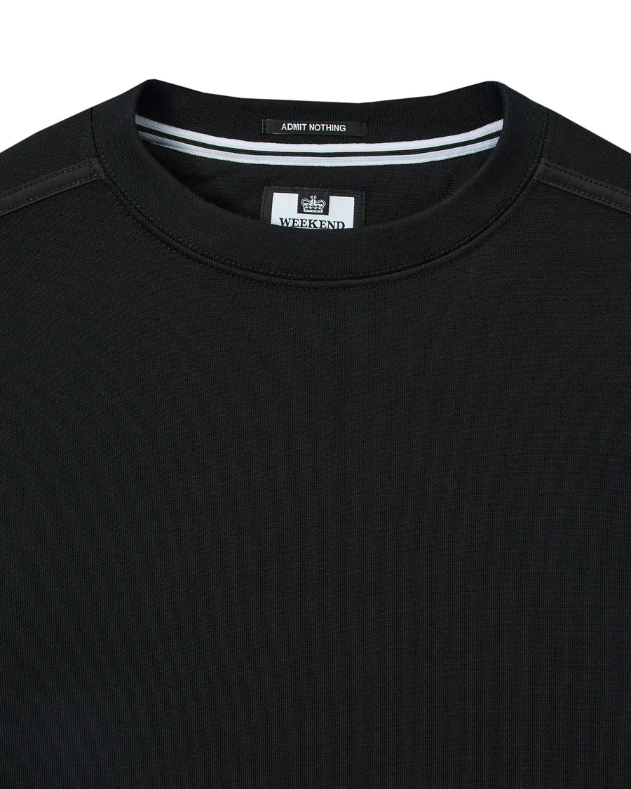 Black t-shirt with a brand label on the collar against a white background