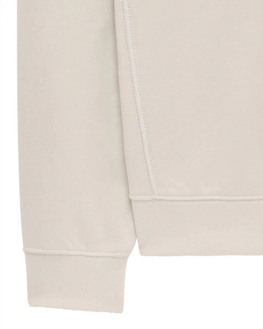 Close-up of a beige sweatshirt with a plain background