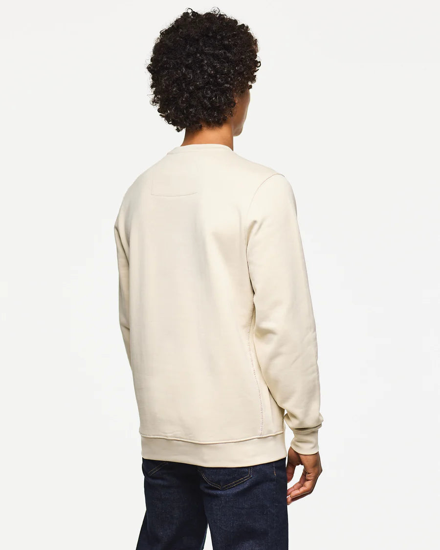 Person wearing a beige sweatshirt on a white background