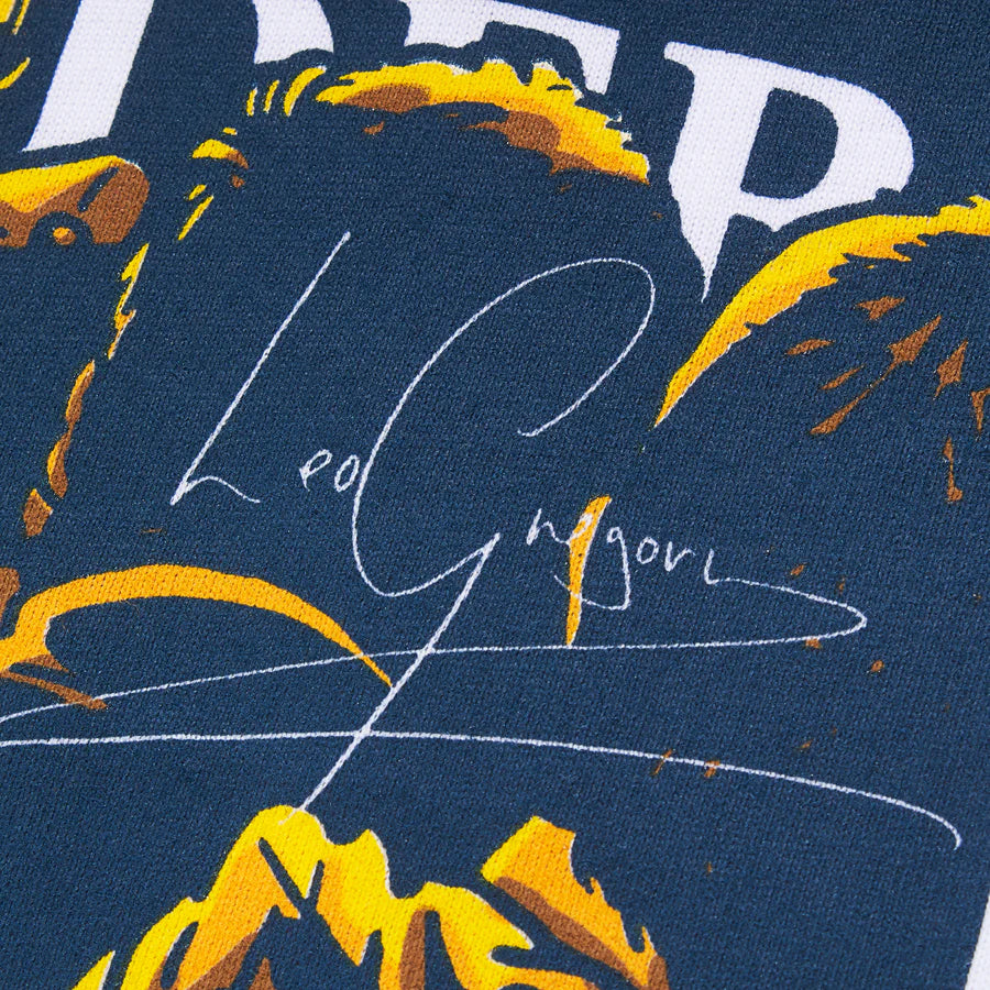 Textured fabric with abstract yellow shapes and a signature on a dark blue background