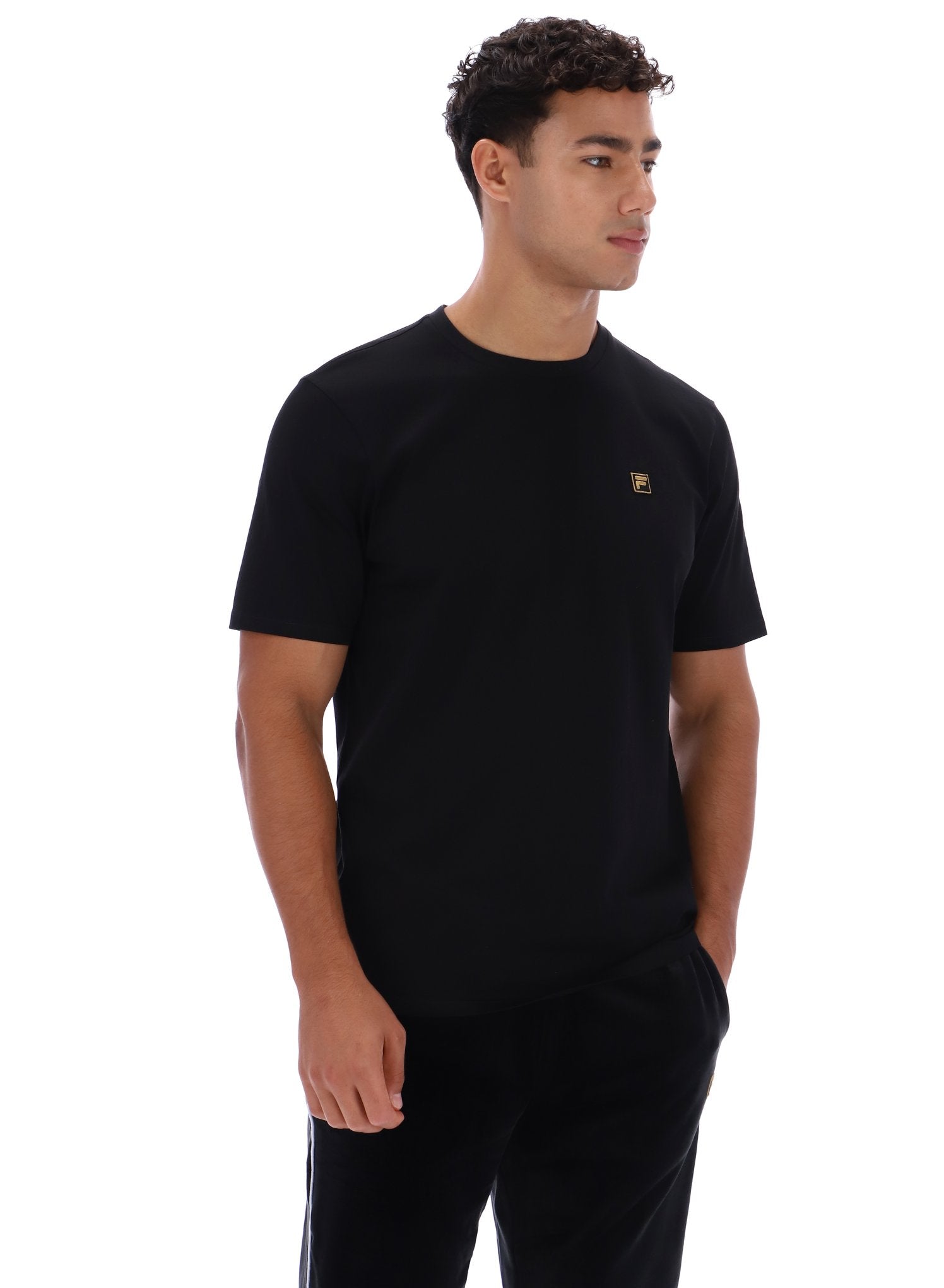Man wearing a black t-shirt with a small logo on a white background