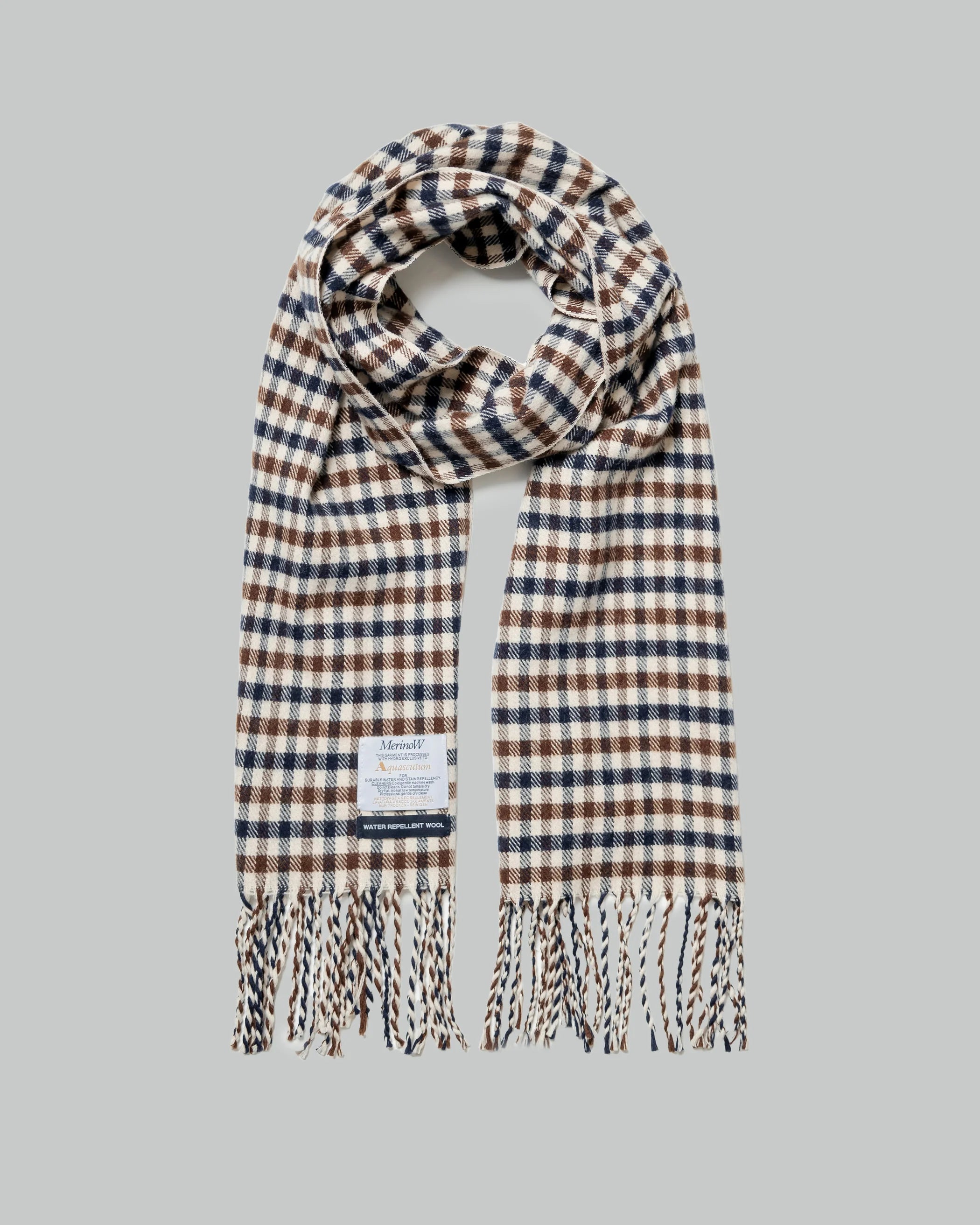 A checkered scarf with a water repellent coating, predominantly in navy and beige colors, with a fabric logo tag on the reverse.