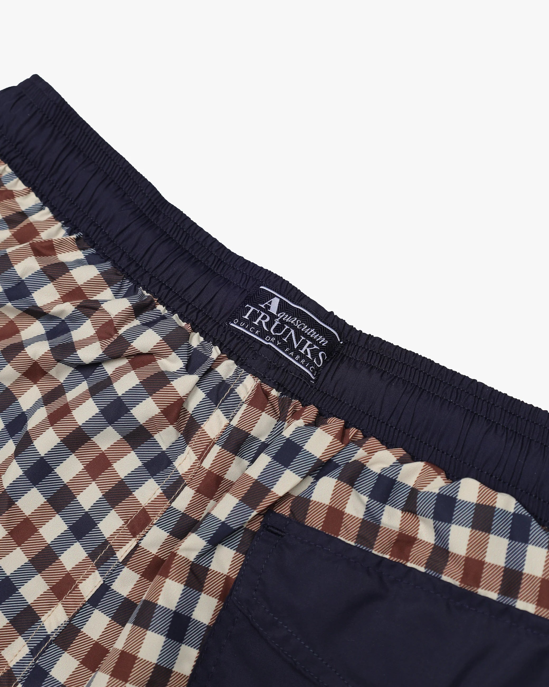 Close-up of checkered boxer briefs with a brand label on a white background