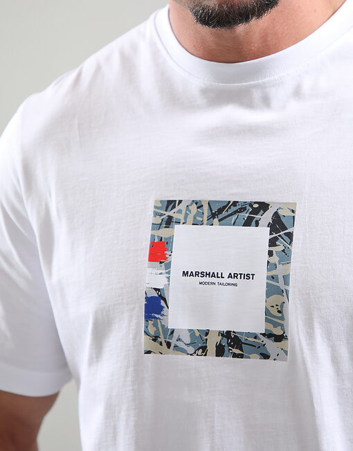 White t-shirt with a colorful square design and text on a plain background