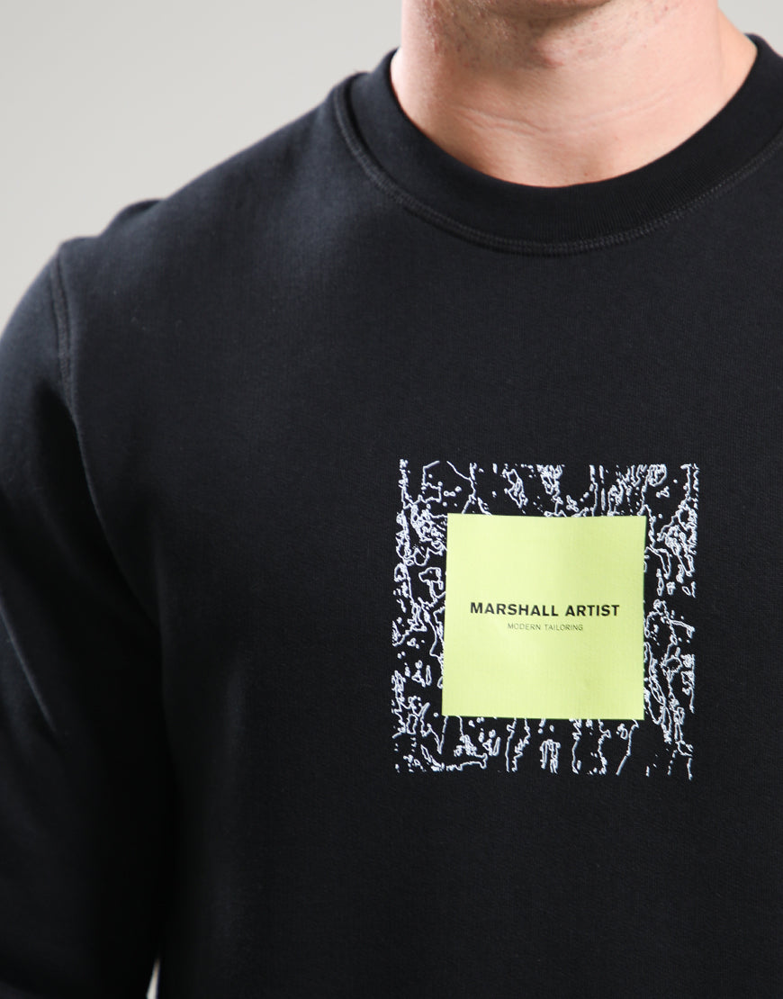 Black sweatshirt with a Marshall Artist logo on a gray background