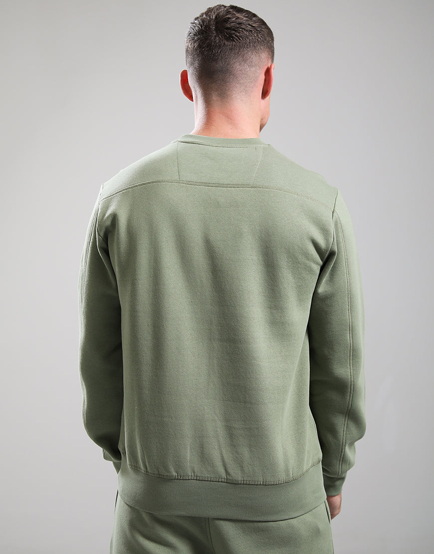 Person wearing a green tracksuit against a gray background