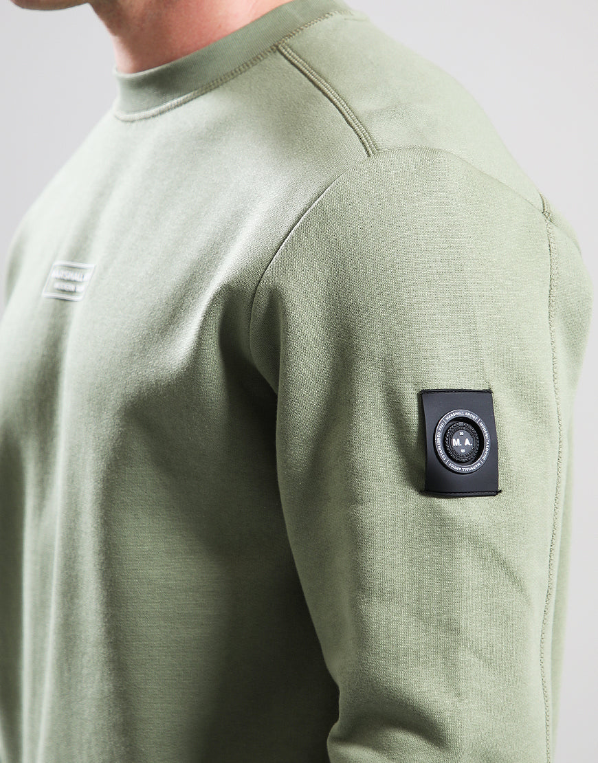 Green sweatshirt with a black patch on the sleeve against a light gray background