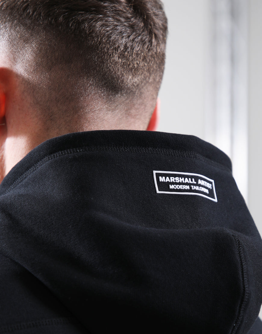 Person wearing a black jacket with a visible brand logo on the back.