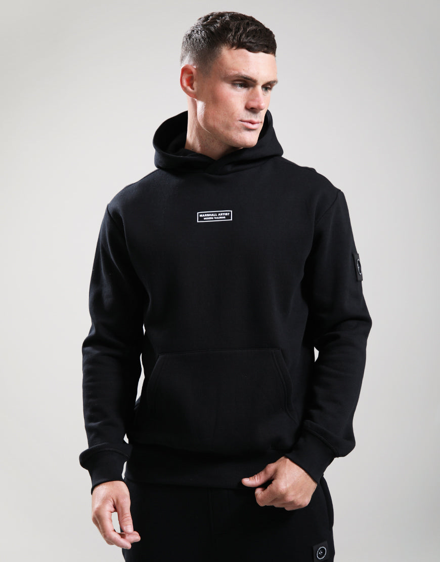 Man wearing a black hoodie with a logo on a gray background