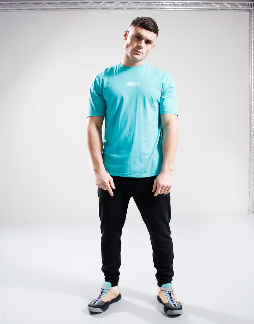 Person wearing a light blue t-shirt and black pants on a white background