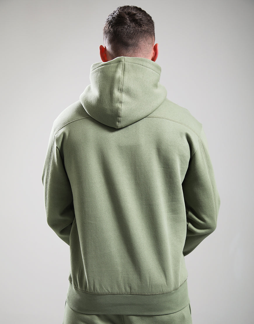 Person wearing a green hoodie from behind on a plain background
