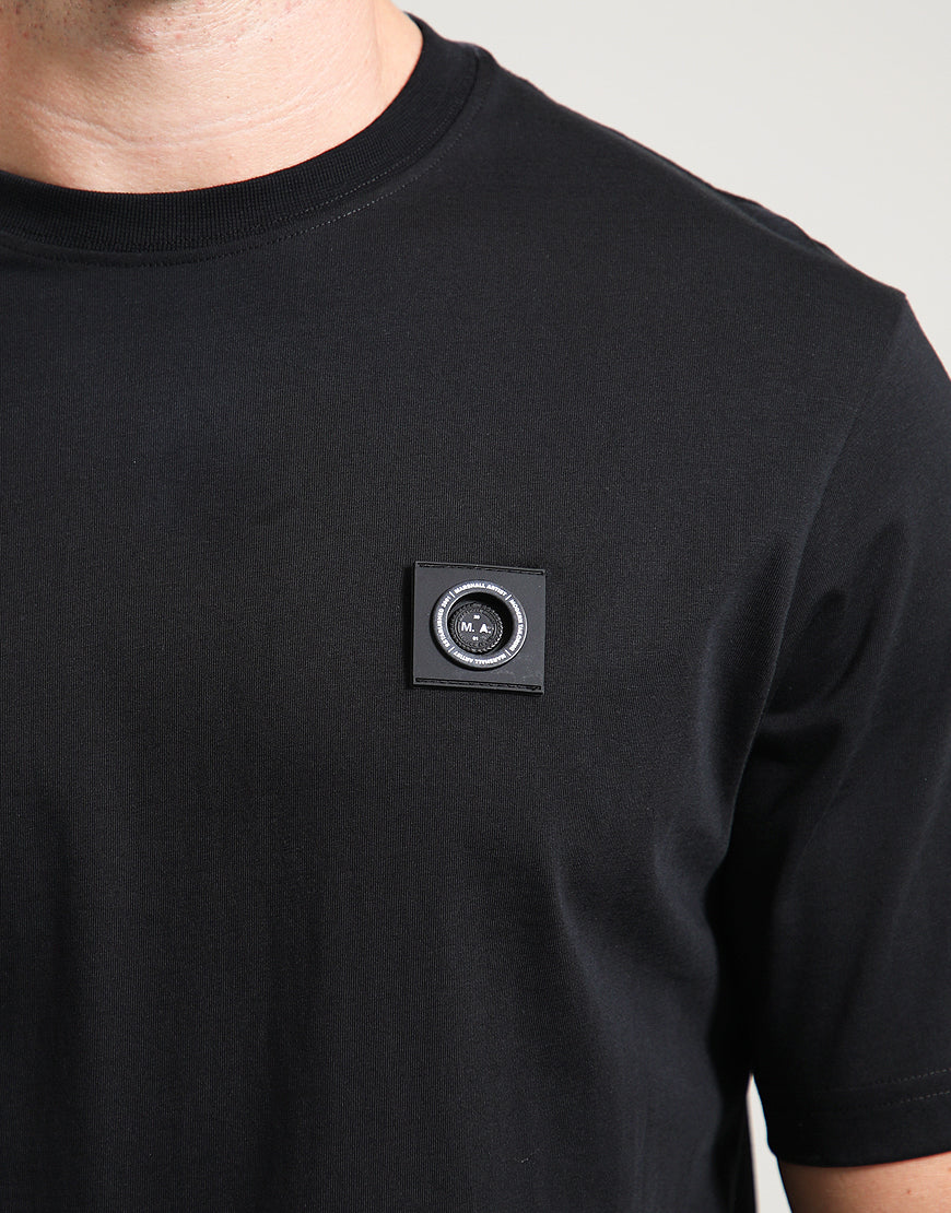 Black t-shirt with a small circular patch on the chest against a neutral background