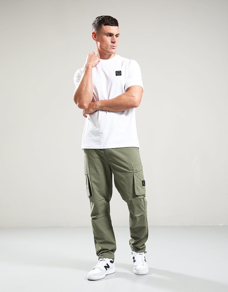 Man wearing a white t-shirt and green cargo pants on a plain background