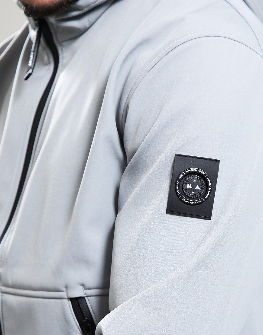 Close-up of a light gray jacket with a brand logo on the sleeve.