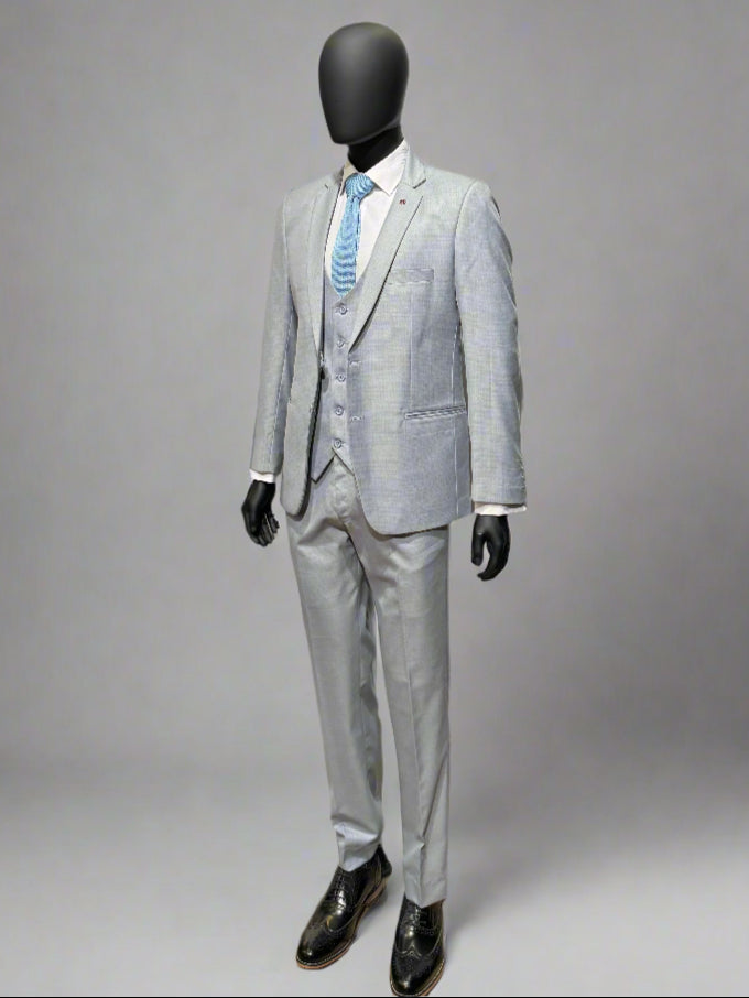 Gray suit with a white shirt and blue tie on a mannequin against a gray background