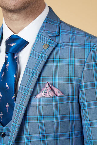 Blue plaid suit jacket with a white shirt and blue tie on a beige background