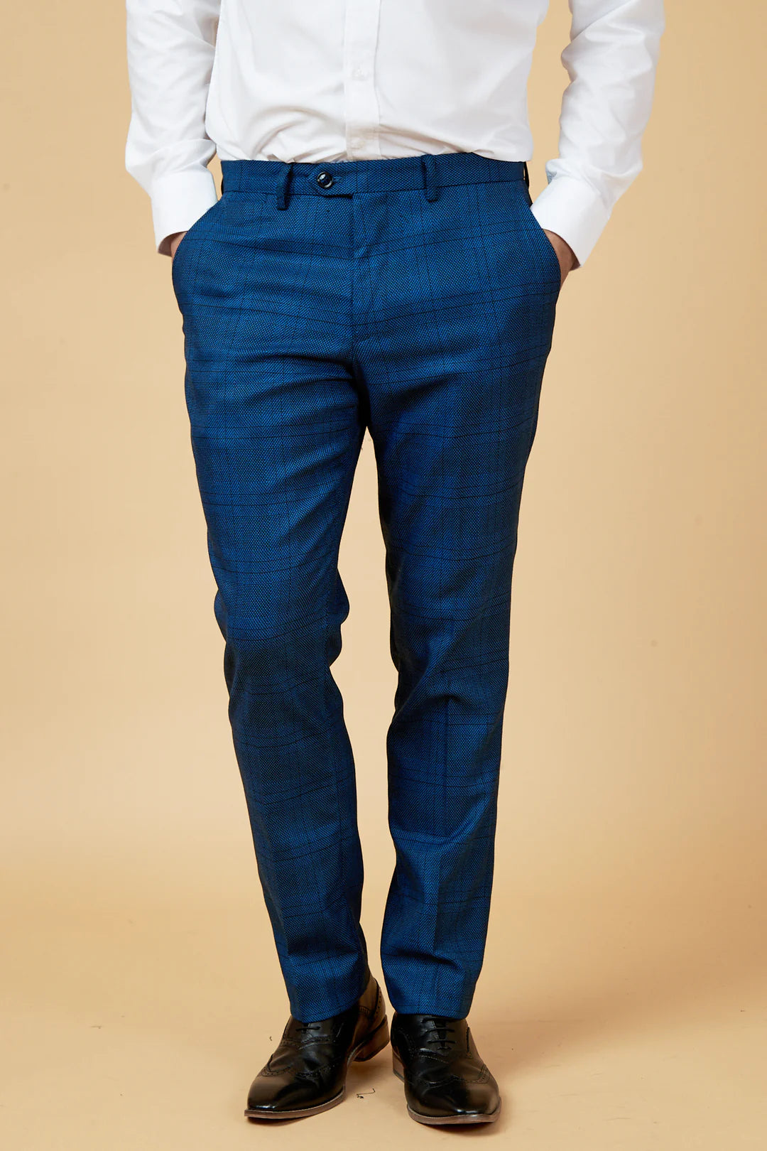 Person wearing blue pants and a white shirt on a beige background