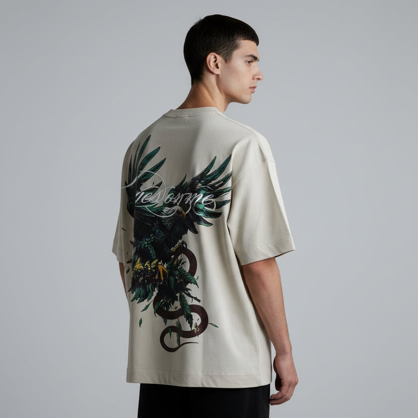 Beige t-shirt with a black and green eagle design on a dark background