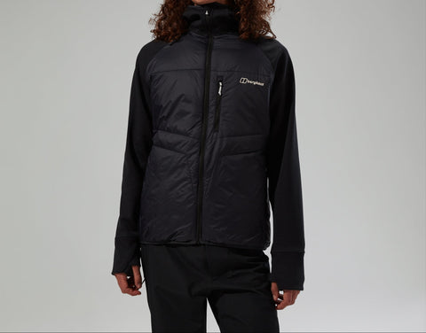 Person wearing a black jacket with a brand logo on a gray background