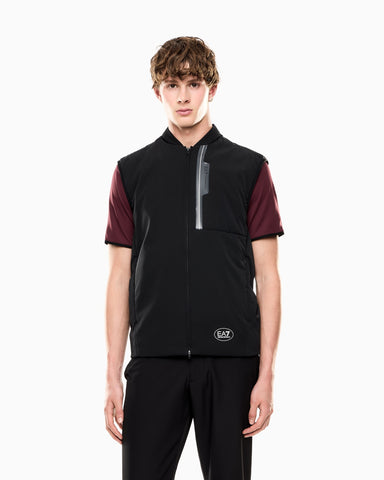 Person wearing a black and maroon vest with a visible brand logo on a white background