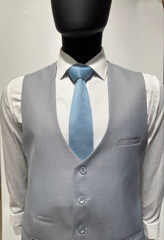 Gray suit jacket with a blue tie being ironed on a white background