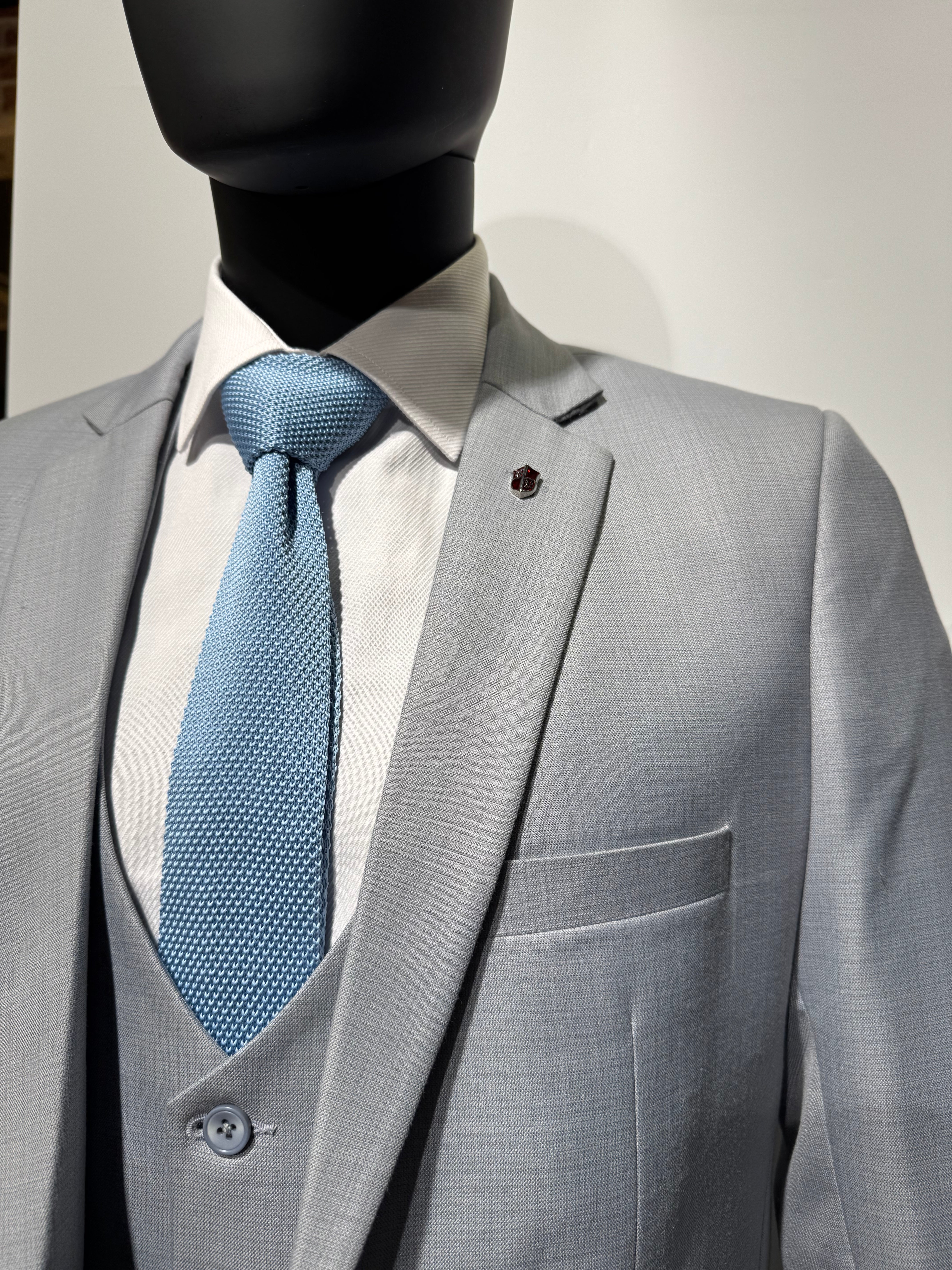 Close-up of a gray suit with a black jacket being worn.