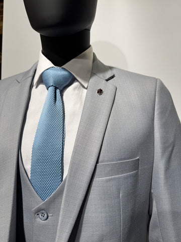Close-up of a gray suit with a black jacket being worn.