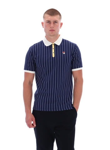 Man wearing a navy pinstripe polo shirt with a white collar and yellow accents on a white background