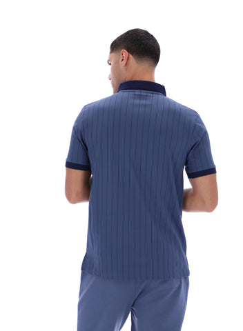 Man wearing a blue ribbed polo shirt and pants on a white background