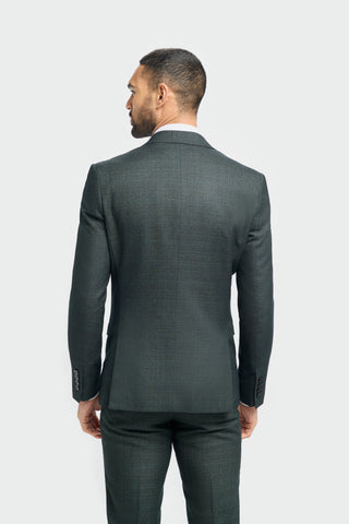 Man wearing a dark green suit on a plain background