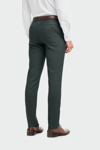 Green trousers worn by a person on a plain background