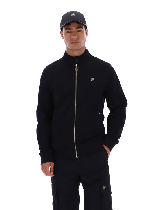 Man wearing a black jacket and pants with a logo on a white background